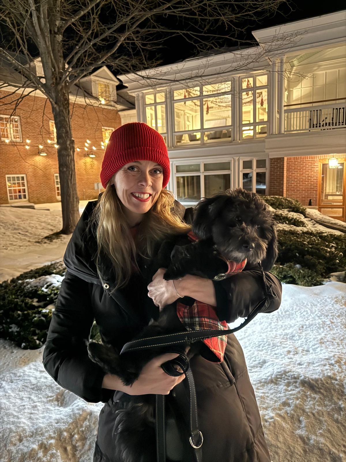 Tamara Sanderson holding her dog on a winter evening in Woodstock, Vermont